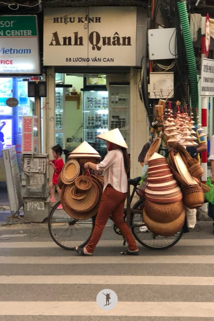 A Vietnamese woman carrying her Non La products using her bicycle in Hanoi, Vietnam