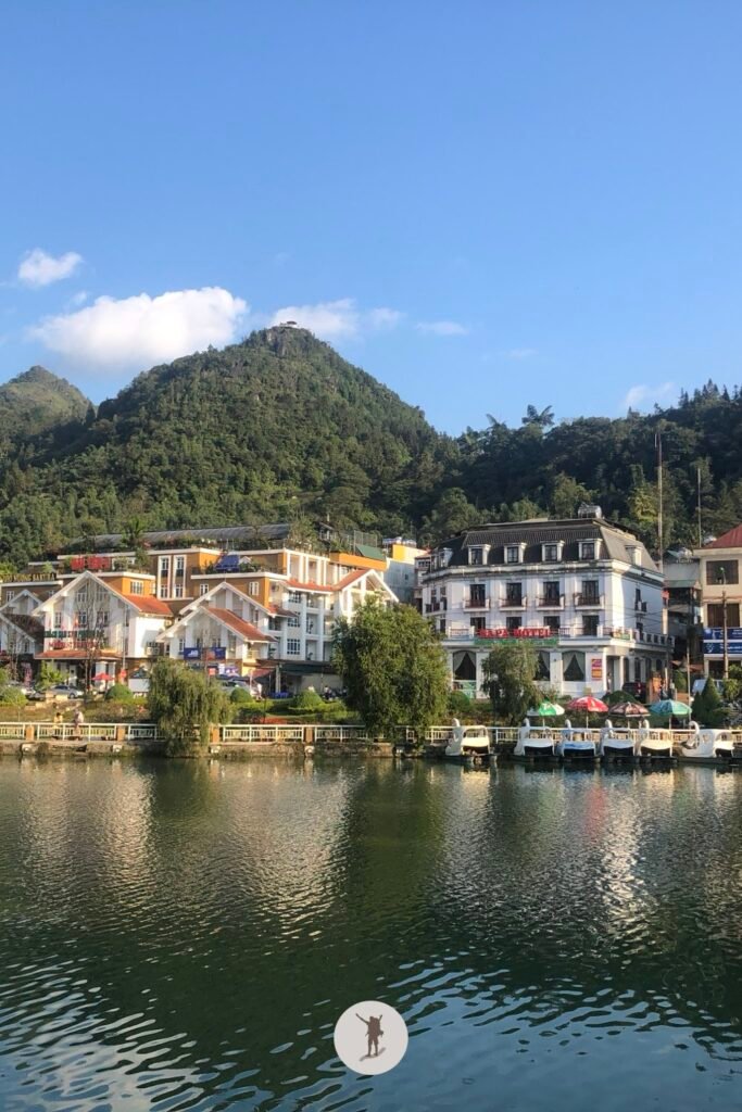 Houses and pedal boats reflected by the water in Lake Sa Pa, Vietnam
