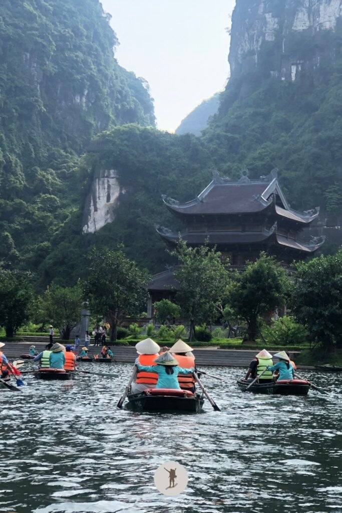 A temple blending in the trees and karst mountains of Trang An, Ninh Binh, Vietnam