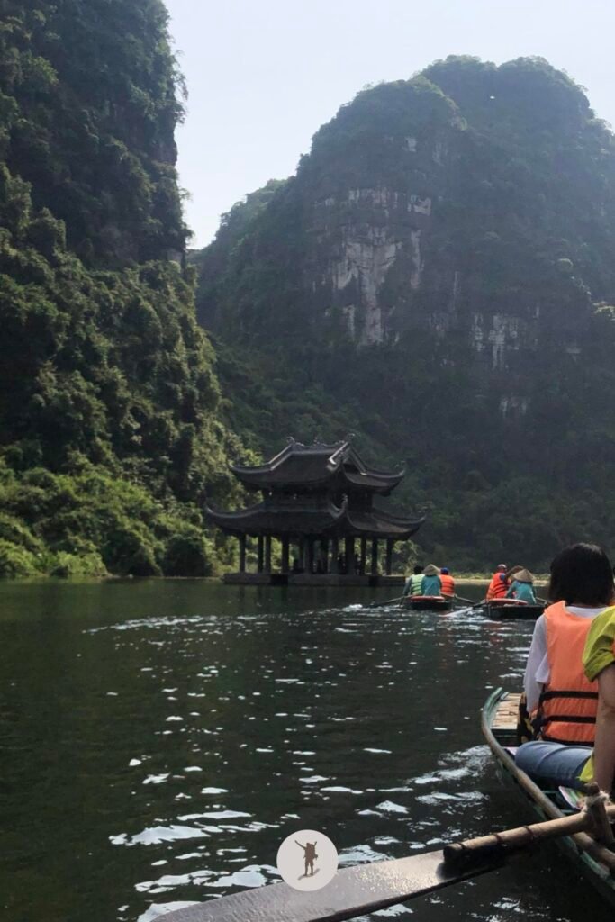 Another perspective of Thuy Dinh Temple standing in the emerald waters of Trang An, Ninh Binh, Vietnam