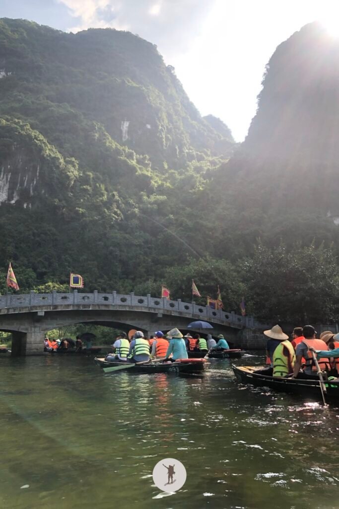 Boats crossing under the bridge in Trang An, Ninh Binh, Vietnam