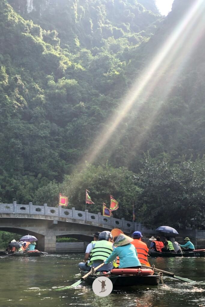 Dramatic sunlight touching the visitors as they wander by boat in Trang An, Ninh Binh, Vietnam
