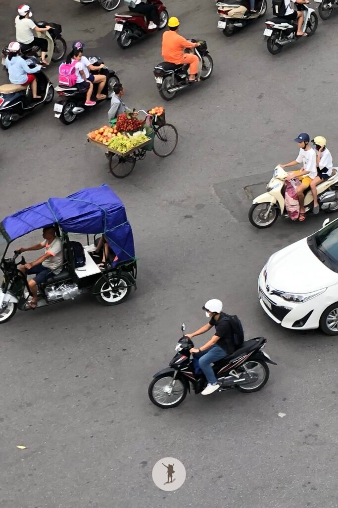 Motorbikes cars and vendors in Dong Kinh Nghia Thuc Square Hanoi Vietnam