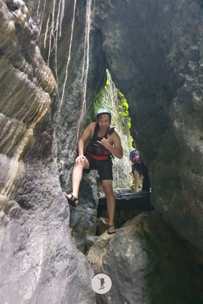 Passing through a hole in a rock along the main route of Kawasan Falls canyoneering, Cebu, Philippines