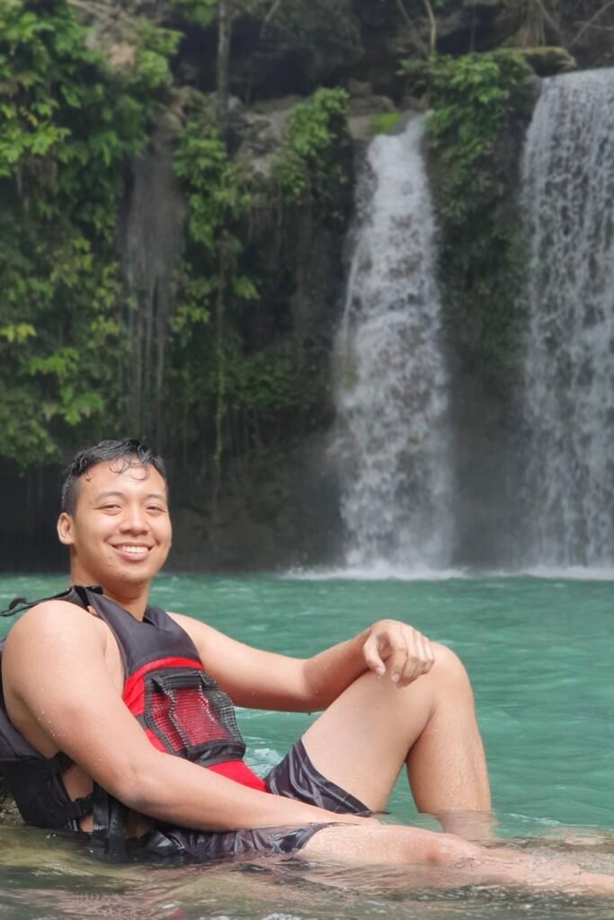 Photo of me taken from another angle and another rock in the pool of Kawasan Falls after canyoneering, Cebu, Philippines