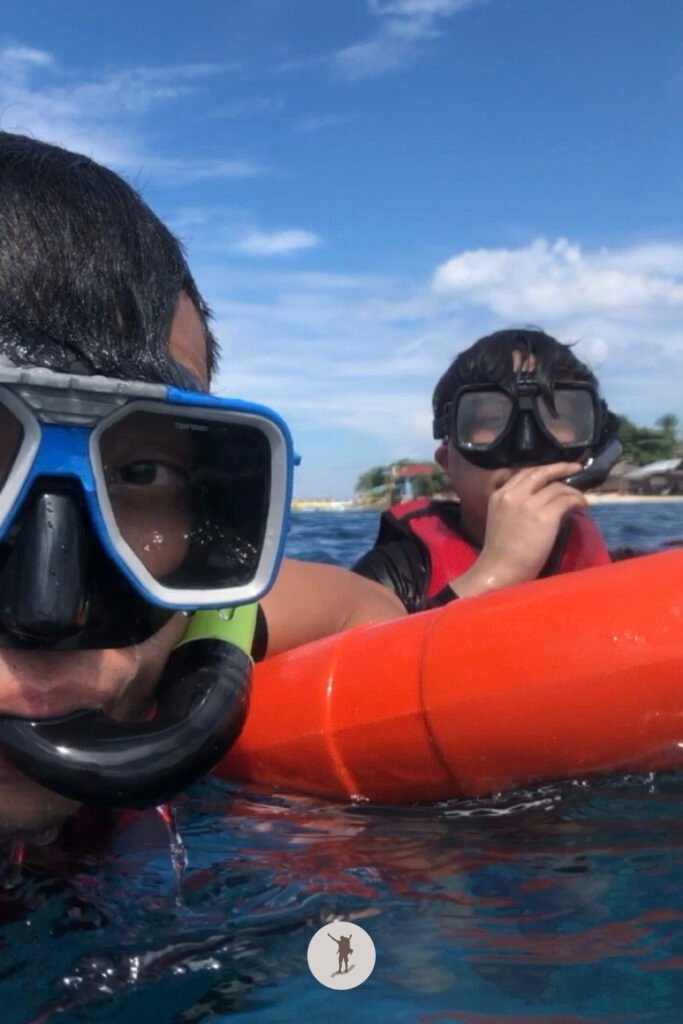 Holding on the lifebuoy during our snorkeling tour as we start looking for Sardine Run, Moalboal, Cebu, Philippines
