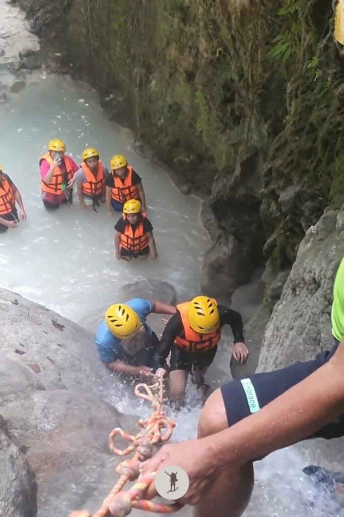 Our guide holding the back of our mate as he climbed to the top of the cascade in Aguinid Falls, Cebu, Philippines