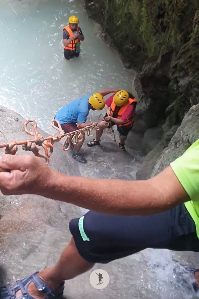 Our guide teaching our friend how she could hold the rope to pull herself up the cascades at Aguinid Falls, Cebu, Philippines