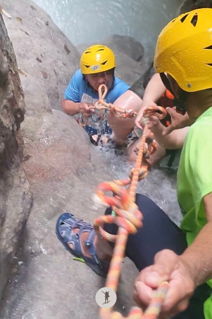 Our two guides helping our friend get to the top of a cascade at Aguinid Falls, Cebu, Philippines