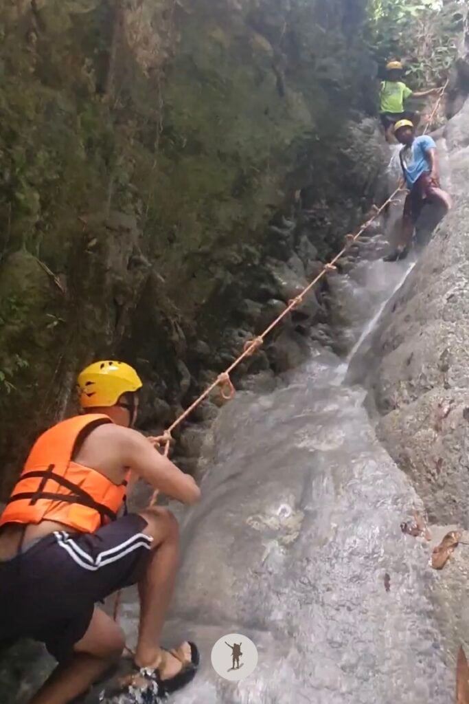 Part 1, a photo of me climbing to the top of the steep cascade at Aguinid Falls, Cebu, Philippines